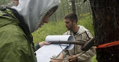 two students making notes in the field